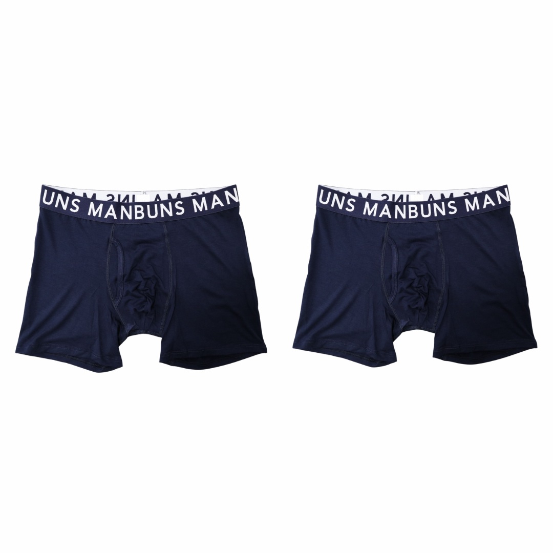 two navy blue manbuns boxer briefs with brand on waist band in front of a white background. 